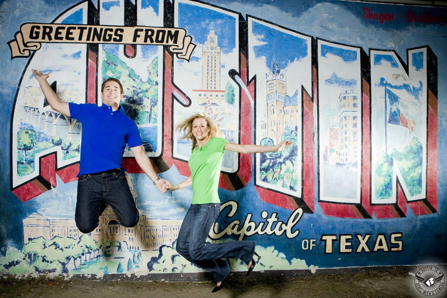 hot blond girl wearing a green short sleeve shirt, blue jeans and black heals jumps with brunette guy in blue collared shirt and blue jeans in front of the greetings austin sign in south austin in this engagement photo near soco 